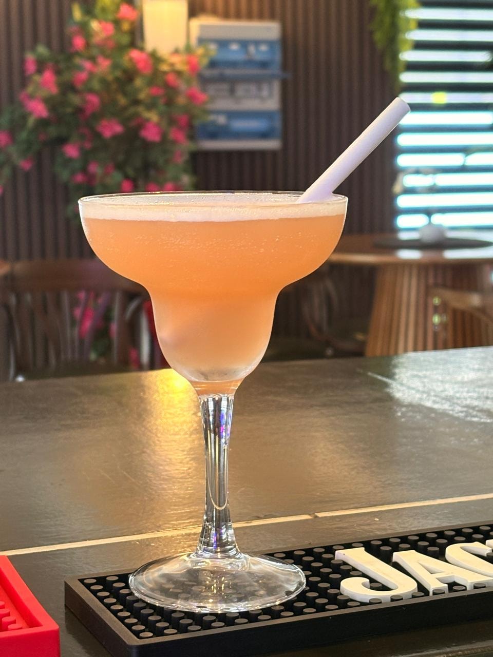 Cocktail orange servi dans un verre à pied au bar Villa Zampa